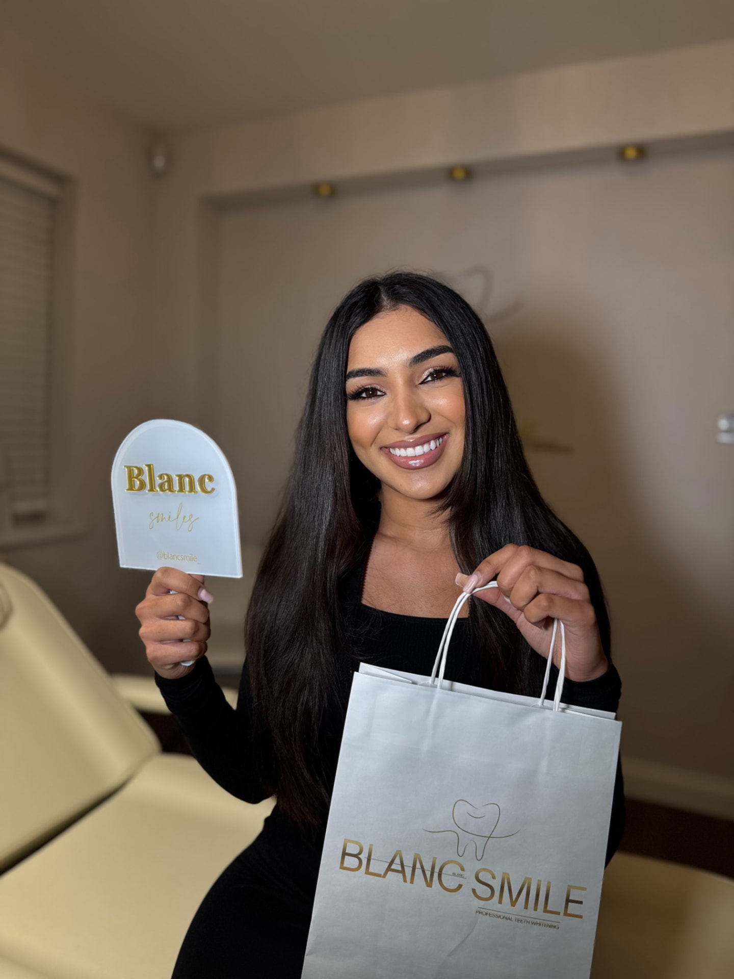 Client holding the signature Blanc Smile hand mirror and branded aftercare bag