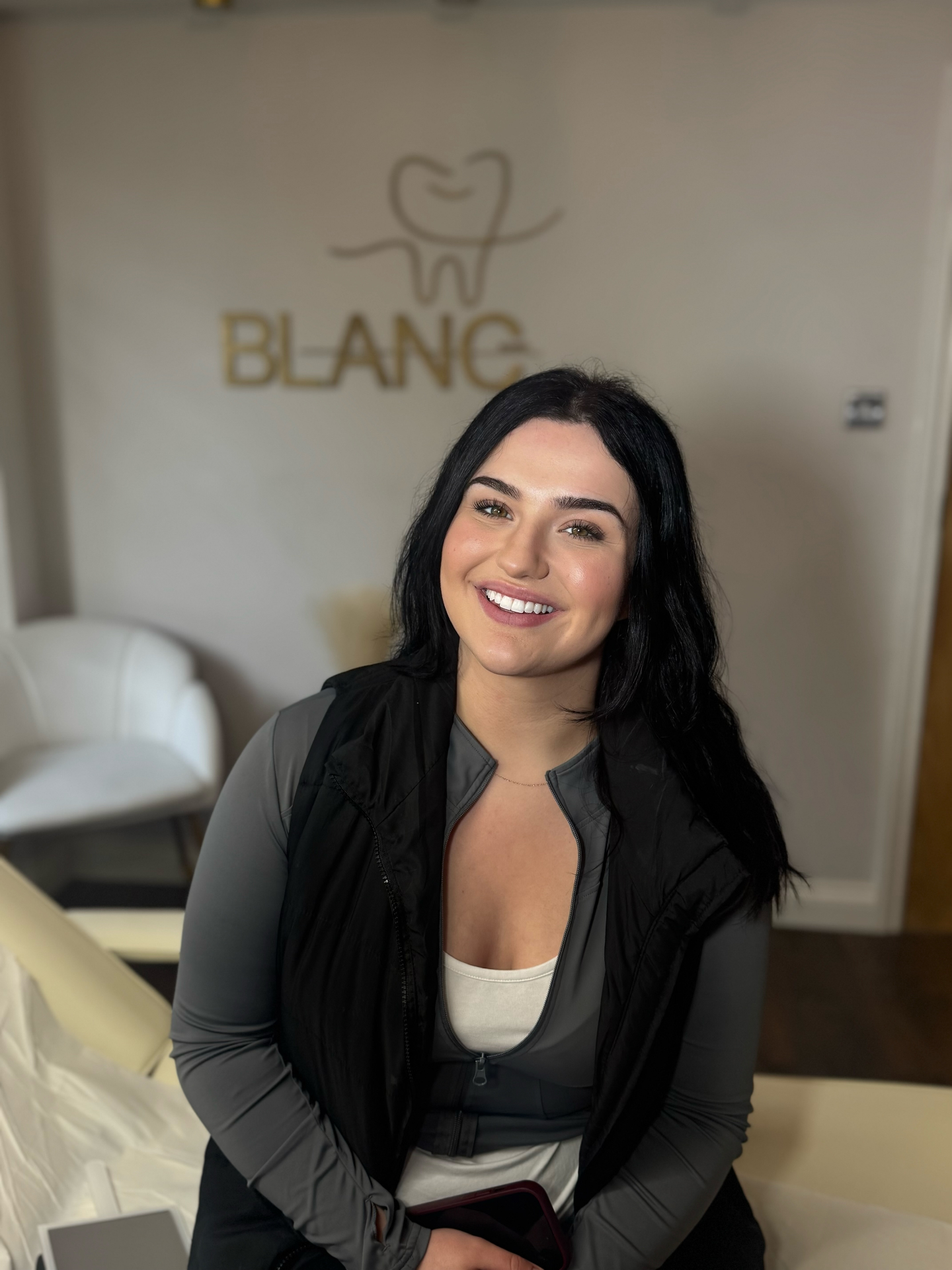 A radiant client smiling after her Blanc Smile whitening session
