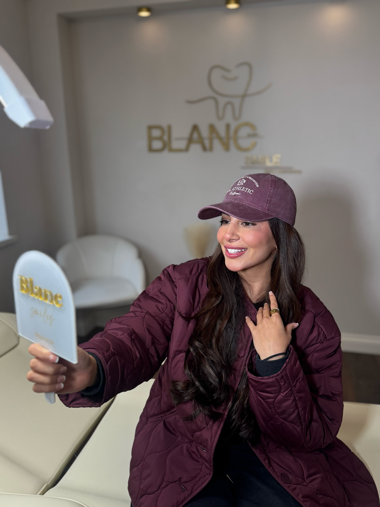 Client admiring her brighter smile in the Blanc Smile hand mirror